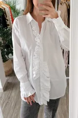 Camisa blanca de manga larga con volados en el frente y en los puños.