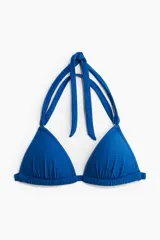 Top de bikini de triángulo azul con copas con relleno que realzan el busto y el escote. Tiras para atar en la espalda y tiras dobles en la nuca. Sin aros. Forrado.