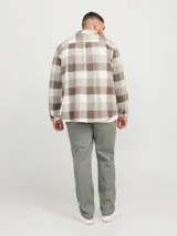 Sobrecamisa a cuadros beige, marrón y blanco, de manga larga y cuello camisero con fit confort. Cierre con botones y bolsillos en el pecho con solapa y broche. Estilo plus size diseñada para cuerpos de talla grande. Tejido de sarga resistente con patrón en “V” característico.