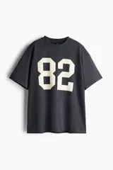 Remera oversized gris oscuro de punto suave de algodón con el número 82 estampado en blanco.