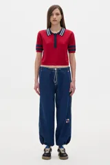 Pantalón jean parachute de denim azul, corte holgado, con cintura y tobillos ajustables con elástico y cordón.