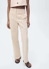 Pantalón de vestir color beige, de tiro medio y corte recto. Confeccionado en algodón con forro interior de poliéster. Presenta trabillas, dos bolsillos laterales y cierre oculto de botón, gancho y cremallera.