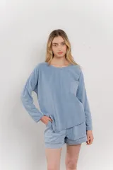 Remera celeste de manga larga con cuello redondo y bolsillo en el pecho.