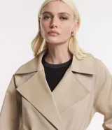 Trench coat largo color beige, de gabardina, con cuello con solapas, doble botonadura, lazo en la cintura, mangas largas con cintas en los puños y bolsillos delanteros.