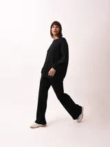Pantalón palazzo negro de tejido de punto con cintura elastizada y cordón ajustable.