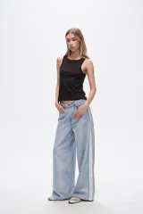 Pantalón de jean celeste de corte ancho con bolsillos y detalle de franja blanca en los laterales.