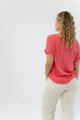 Remera blanca de viscosa liviana, con escote redondo y mangas cortas con vuelta.