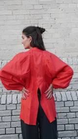 Camisa verde agua de lino, con botones de guampa, más larga atrás que adelante y espalda con tajo en el medio.