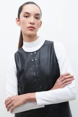 Vestido de eco cuero negro, con tachas decorativas y corte recto.