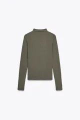 Camiseta blanca de manga larga con cuello alto y corte ajustado.