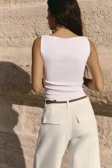 Camiseta sin mangas a rayas horizontales blancas y negras, con cuello barco y corte ajustado.