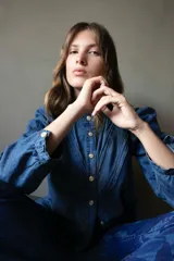 Camisa gris de jean liviano con cuello mao, cierre frontal con botones dorados, mangas 3/4 con puños fruncidos y detalle de costuras horizontales en el pecho.