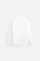 Camisa celeste de algodón, corte relaxed fit, cuello abotonado, manga larga con puños abotonados y cierre frontal con botones.