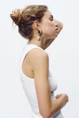 Aros colgantes dorados con forma de concha y perla irregular colgante.