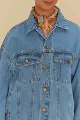 Chaqueta vaquera azul de corte oversize, con cuello clásico, cierre de botones, bolsillos frontales y puños abotonados.