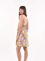 Vestido corto con estampado de hojas en tonos rosa, amarillo, verde y blanco.