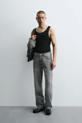 Pantalón de jean celeste de corte flare, con tiro medio, cinco bolsillos, cierre frontal con cremallera y botón, y bajo con acabado irregular.