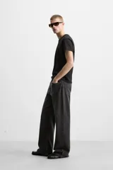 Pantalón de jean celeste con efecto lavado, corte flare fit y caída baggy desde la rodilla hasta el tobillo. Tiene cinco bolsillos y cierre frontal con botones.