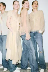 Jeans de tiro bajo color azul claro, con corte bootcut, cinco bolsillos y cierre frontal de cremallera y botón.