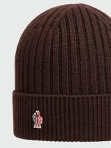 Gorro de lana con diseño de punto elástico en color negro, con vuelta y el icónico parche del logotipo de Moncler en la parte frontal.