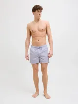 Short de baño lila con cintura elástica ajustable con cordón. Estampado lateral con el logo de la marca y texto en blanco.