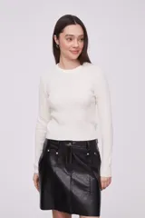 Sweater de punto color crudo con textura de trenzas y manga larga.