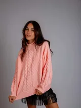 Sweater tejido de punto trenzado color rosa, de cuello alto y corte holgado.