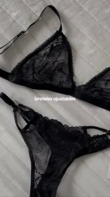 Conjunto de lencería de encaje negro, compuesto por un corpiño triangular con breteles regulables y una bombacha less con tiras regulables.