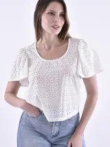 Blusa blanca con bordado inglés, cuello redondo y mangas cortas abullonadas.