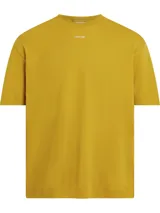 Remera color mostaza de corte holgado, con cuello redondo y logo de Calvin Klein estampado en el pecho.