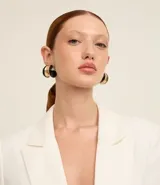 Caravanas de aro con diseño curvado y orgánico, presentan un contraste de acabado brillante en colores negro y dorado. Cuentan con cierre de perno y tuerca.