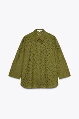 Camisa amarilla de cuello solapa y manga larga acabada en puño. Detalle de bordados perforados a tono. Cierre frontal con botones ocultos por solapa.