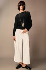 Pantalón culotte color verde oliva, de tiro medio y pierna ancha. Incluye cinturón ajustable con hebilla metálica y cierre lateral con cremallera oculta.