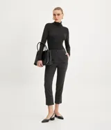 Suéter de punto color blanco, con cuello alto estructurado, manga larga y efecto texturizado.