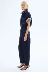 Pantalón de jean azul oscuro de corte holgado, con tiro alto, cinco bolsillos y cierre con botón.