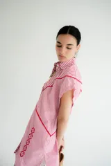 Vestido corto tipo camisa color beige con bordados florales en azul.