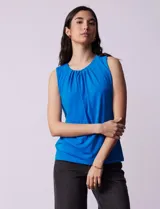 Blusa sin mangas color amarillo, con cuello redondo con frunces delanteros y abertura con botón en la espalda.