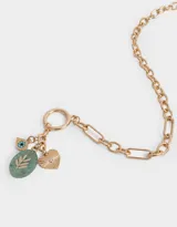 Collar dorado con cadena de eslabones y cierre de aro con barra en la parte delantera. Incluye dijes colgantes: piedra verde ovalada con diseño de hojas, ojo turco y corazón dorado con textura.