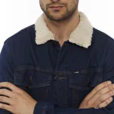 Campera de jean azul con forro de sherpa color crema en el cuello y el interior. Tiene bolsillos con solapa en el pecho, bolsillos laterales y cierre con botones.