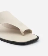 Sandalia plana tipo mule color crema, con puntera cuadrada, tira ancha en la parte superior y detalle de dedo.
