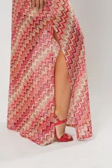 Vestido midi de tejido de punto con diseño de ondas en tonos rosa, rojo, beige y blanco. Tiene un solo tirante y corte al bies.