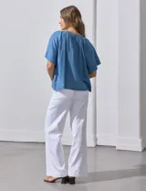 Blusa celeste de lyocell con escote en V, punto smock y lazo de ajuste.