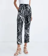Pantalón pijama fluido de viscosa con estampa geométrica en blanco y negro. Tiene cintura media con ajuste de cordón con puntera metálica, bolsillos y prega frontal.