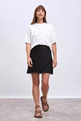 Remera blanca de algodón con cuello redondo y mangas cortas con aberturas laterales.