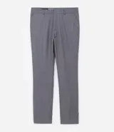 Pantalón de vestir gris, de corte slim fit, con bolsillos laterales y traseros. Se ajusta a la cintura con cinturón de cuero negro.