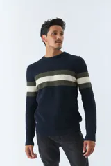 Sweater de punto azul marino con rayas horizontales en el pecho de color verde oliva y blanco. Tiene cuello redondo y puños acanalados.