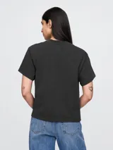 Remera rosa con estampado de la banda Nirvana y logo en verde y celeste.