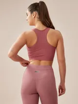 Top deportivo gris oscuro con espalda deportiva y banda elástica en el bajo busto.