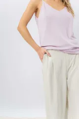 Pantalón negro de corte ancho y fluido, tiro medio con presillas para cinturón, bolsillos laterales funcionales y pinzas delanteras.