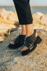 Sandalias de cuero vacuno color marrón, con tiras anchas cruzadas en el empeine, elástico en el talón y doble suela de goma deportiva.